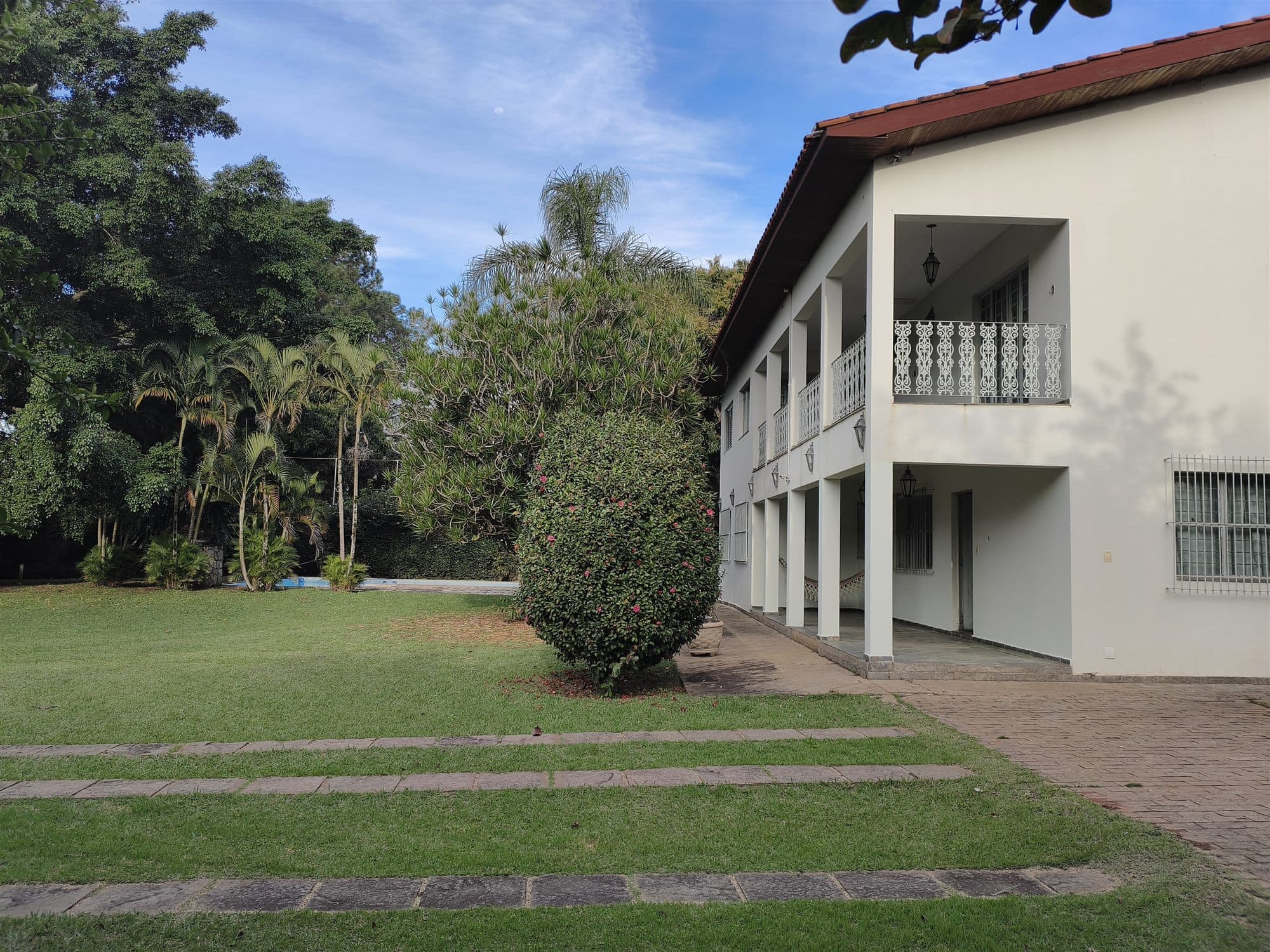 A casa vista do gramado, com a varanda nos dois pavimentos e a rede armada embaixo