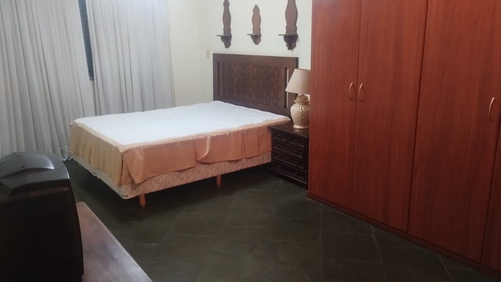 O outro quarto de casal, com a cama arrumada, a cortina nova e o armário embutido